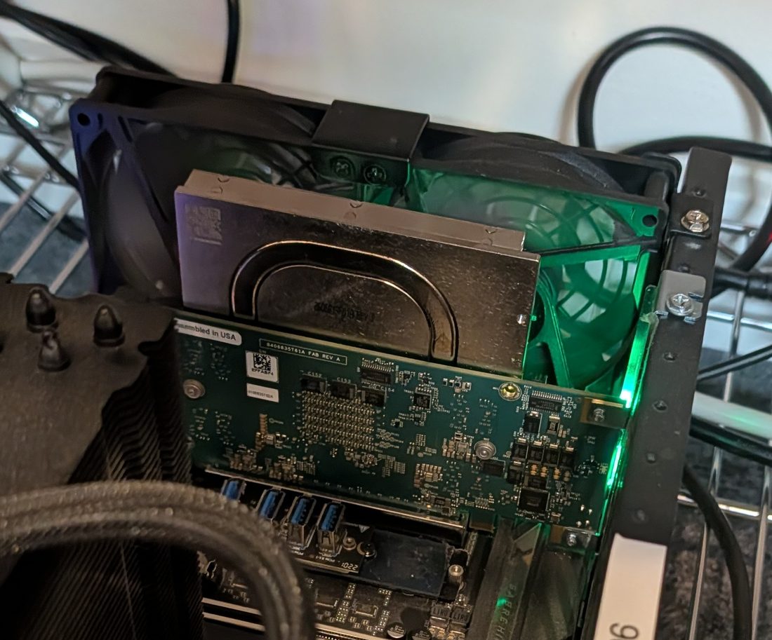 A single-card lab frame on 2 October: the ET card's heat-pipe plate in front, and a 120 mm fan with green lights clipped to the frame behind it.